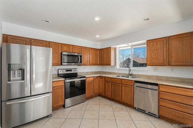 kitchen featuring light tile patterned floors, appliances with stainless steel finishes, light countertops, and a sink