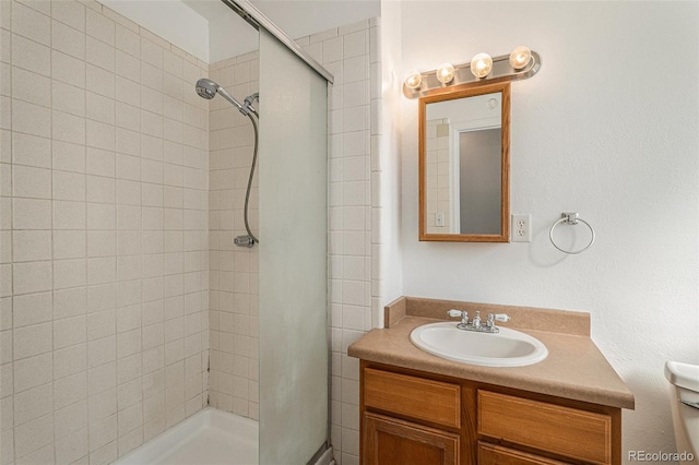 bathroom featuring a shower stall, toilet, and vanity