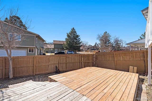 wooden terrace featuring a residential view and a fenced backyard