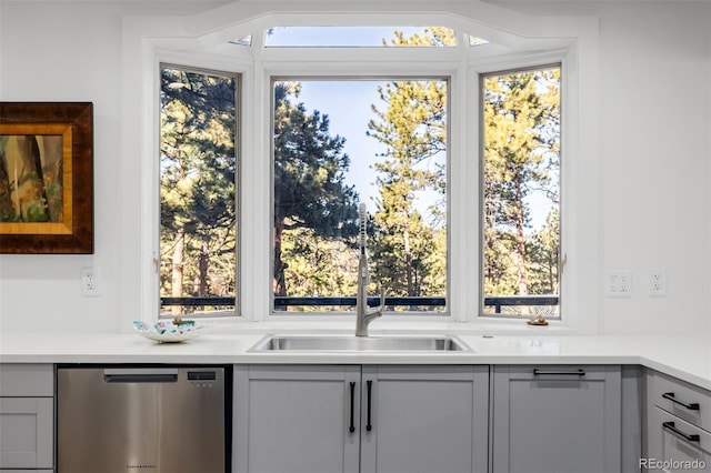 bar with a sink, stainless steel dishwasher, and plenty of natural light