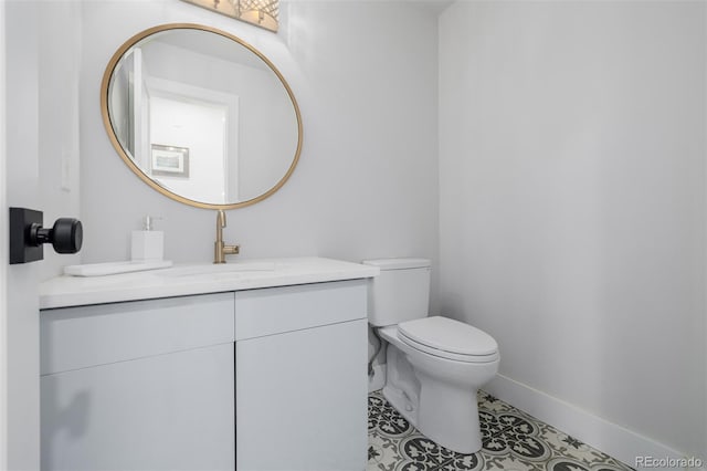 bathroom with vanity, toilet, baseboards, and tile patterned flooring