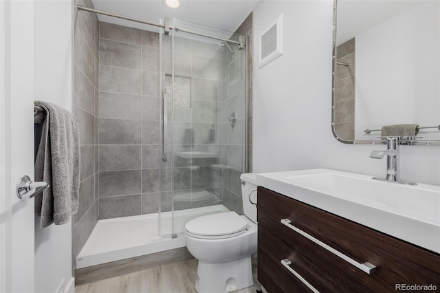 full bath featuring toilet, wood finished floors, visible vents, a shower stall, and vanity