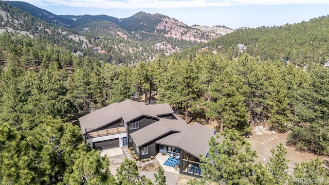 birds eye view of property with a mountain view and a wooded view