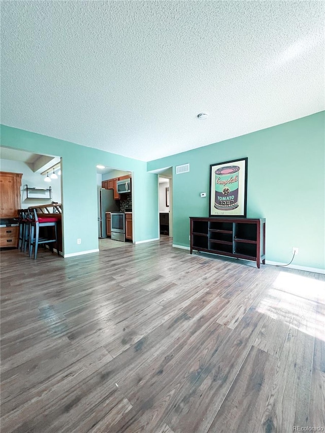 unfurnished living room with a textured ceiling and hardwood / wood-style floors