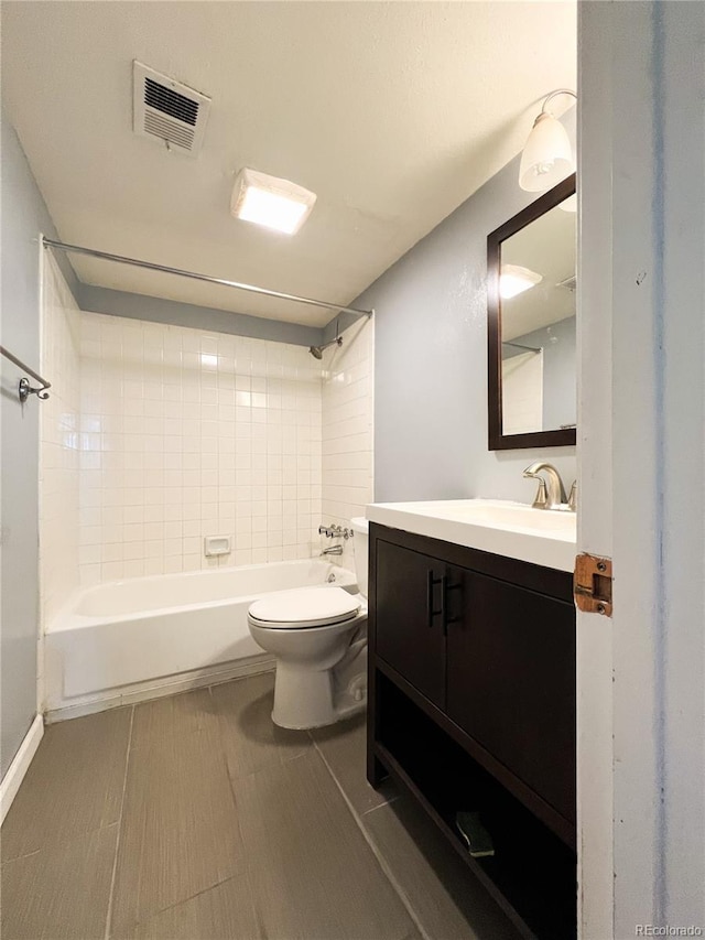 full bathroom with tiled shower / bath, vanity, and toilet