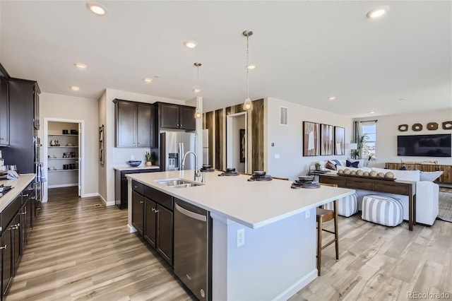 1320 Loraine Cir N, Lafayette, CO 80026 - kitchen featuring a sink, stainless steel appliances, open floor plan, light wood finished floors, and light countertops