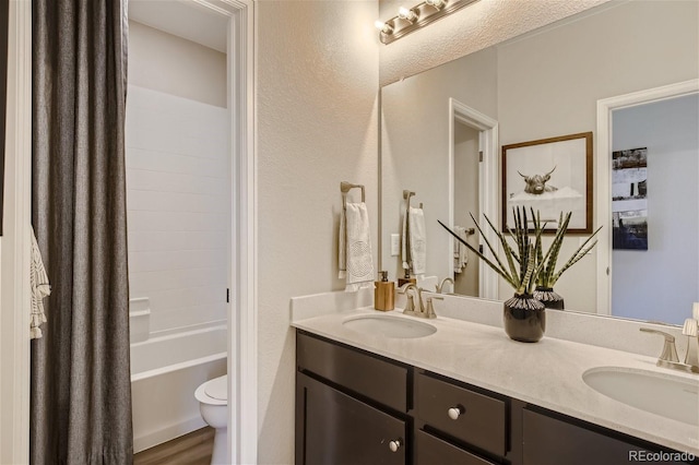 1320 Loraine Cir N, Lafayette, CO 80026 - full bath with double vanity, toilet, shower / bath combo with shower curtain, wood finished floors, and a textured wall