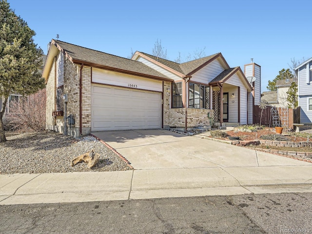 ranch-style house featuring a garage, brick siding, driveway, and fence