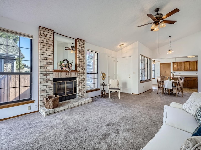 living area with carpet floors, lofted ceiling, a brick fireplace, and a healthy amount of sunlight