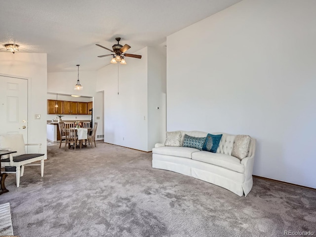 unfurnished living room with carpet floors, high vaulted ceiling, a textured ceiling, and a ceiling fan