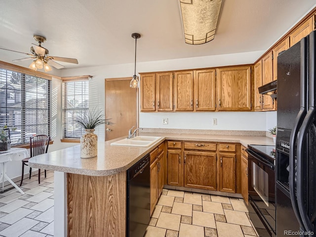 kitchen with brown cabinetry, light countertops, a sink, and black appliances