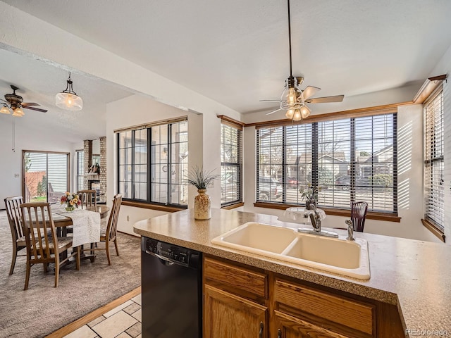 kitchen with brown cabinetry, dishwasher, ceiling fan, light countertops, and a sink