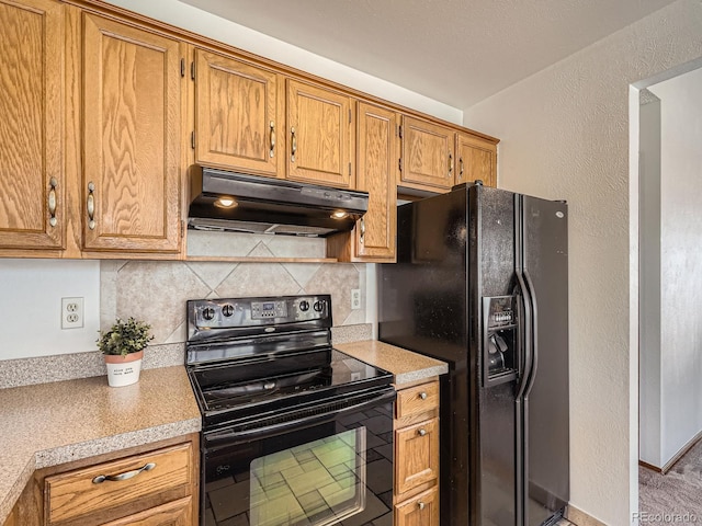 kitchen featuring black appliances, under cabinet range hood, light countertops, and backsplash