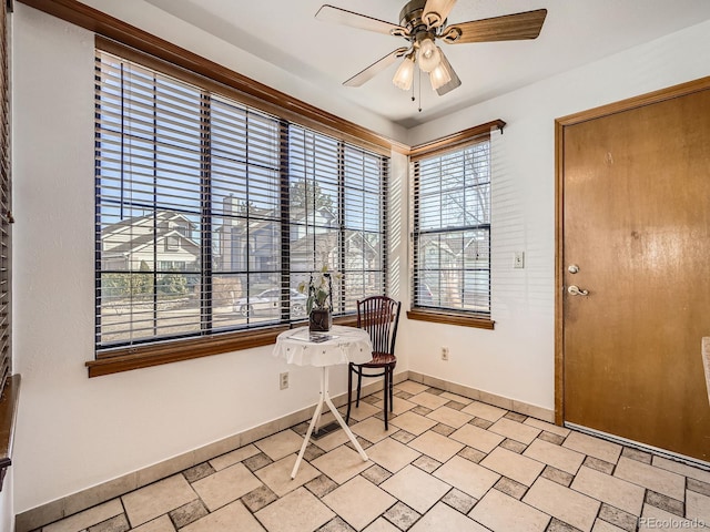 interior space with stone finish flooring, ceiling fan, and baseboards