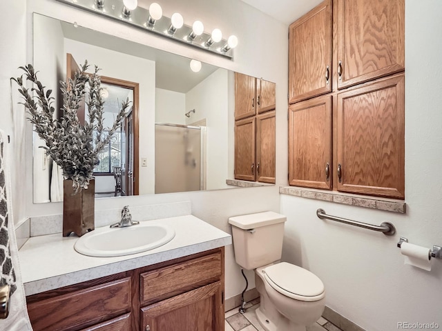 bathroom with toilet, a stall shower, baseboards, and vanity