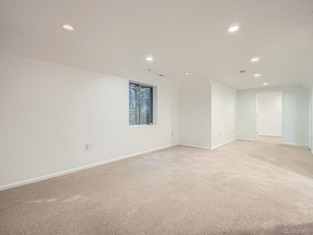 empty room with baseboards, recessed lighting, and light colored carpet