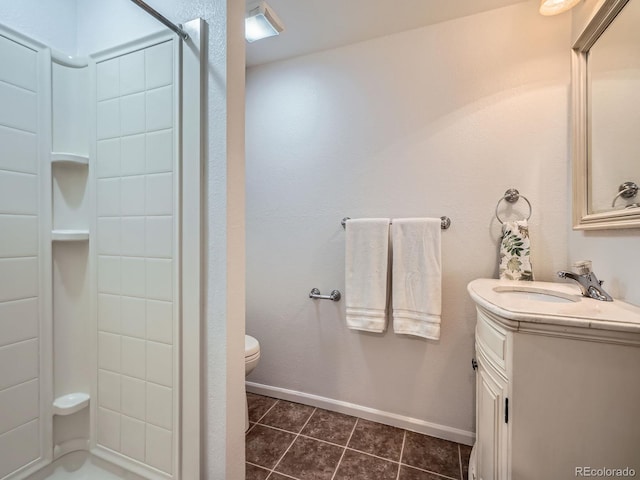 full bath featuring toilet, a stall shower, vanity, baseboards, and tile patterned floors