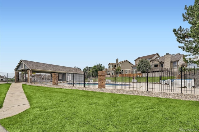 surrounding community with a yard, a swimming pool, fence, and a residential view