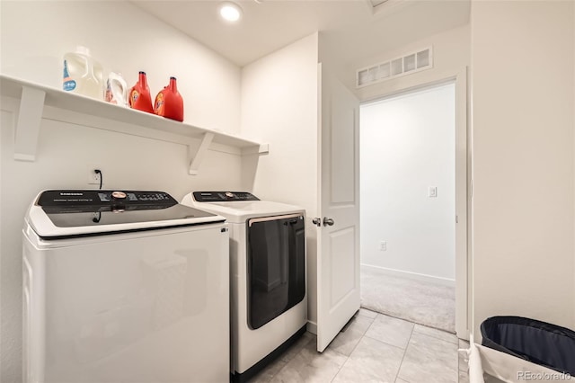 laundry room featuring washing machine and clothes dryer and light carpet