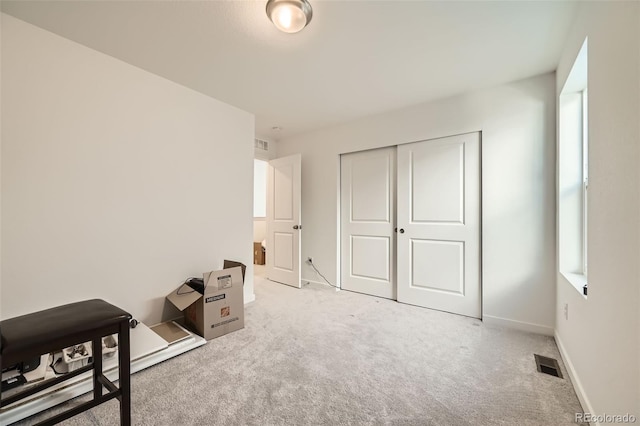 bedroom featuring multiple windows, a closet, and light carpet