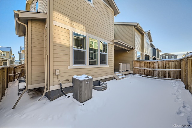 snow covered property featuring central AC