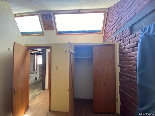 bedroom featuring a closet, hardwood / wood-style floors, and a skylight