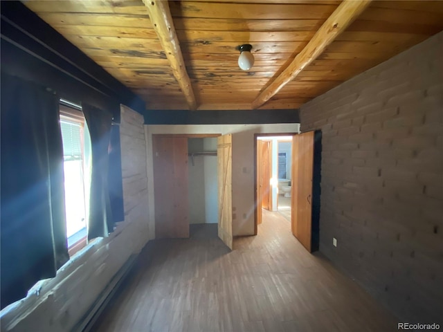 unfurnished bedroom featuring beamed ceiling, hardwood / wood-style flooring, a closet, and wood ceiling