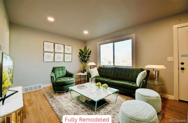 living room featuring recessed lighting, wood finished floors, visible vents, and baseboards