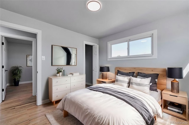 bedroom with light wood finished floors and baseboards