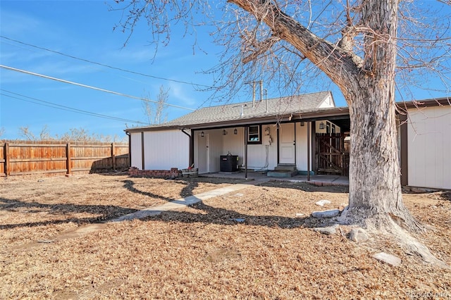 back of property featuring central air condition unit, covered porch, and fence