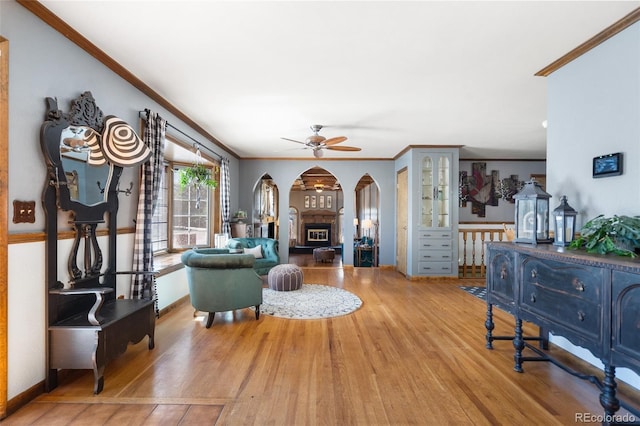 living room with hardwood / wood-style floors, ceiling fan, and crown molding