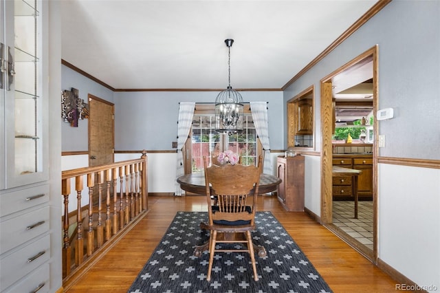 dining room with crown molding, a chandelier, and light wood-type flooring