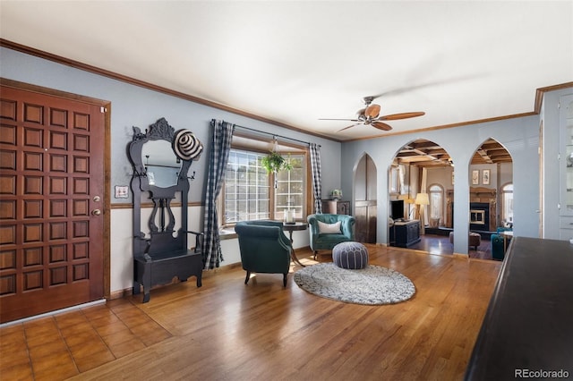 interior space with ceiling fan and ornamental molding