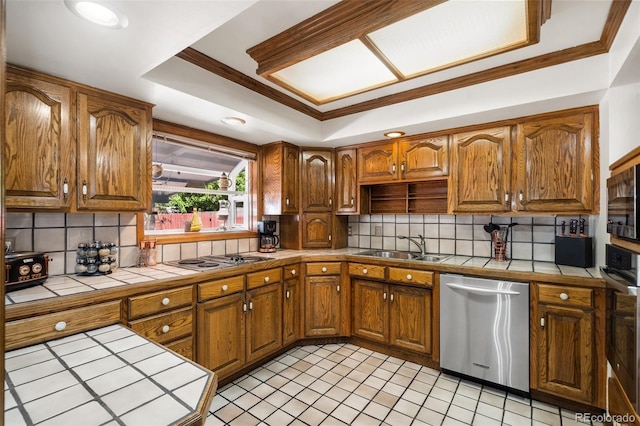 kitchen with tile countertops, a raised ceiling, crown molding, sink, and stainless steel appliances