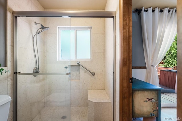 bathroom with toilet and a shower with door