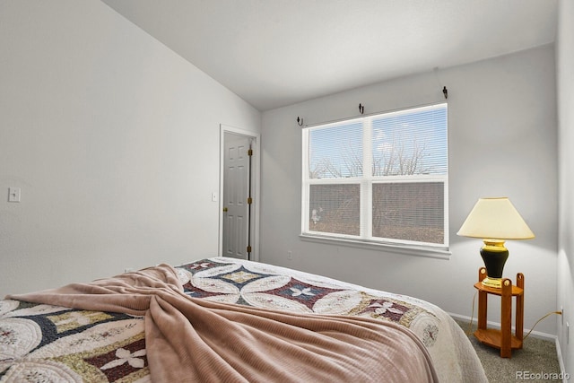 bedroom with lofted ceiling, carpet flooring, and baseboards