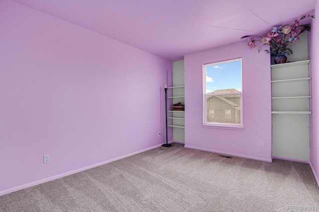 carpeted empty room with baseboards