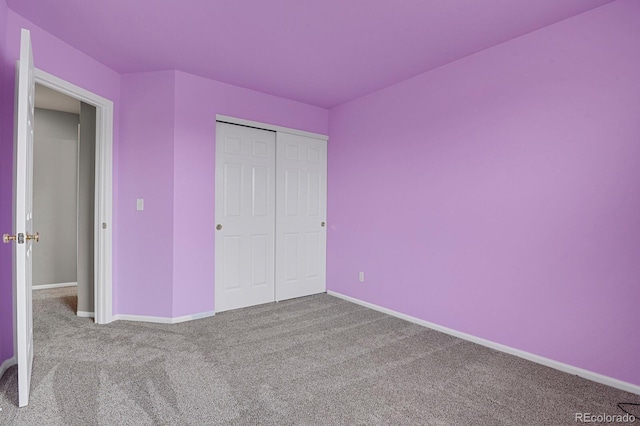 unfurnished bedroom with a closet, baseboards, and carpet flooring