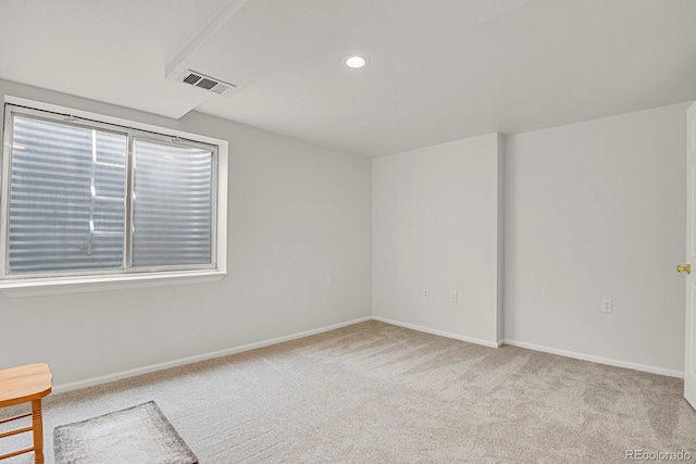 spare room with light carpet, recessed lighting, visible vents, and baseboards