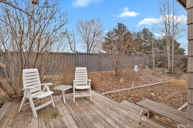 wooden terrace with a fenced backyard