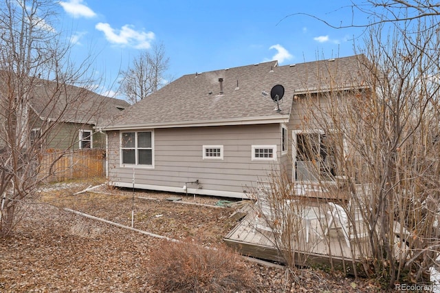 back of property featuring roof with shingles