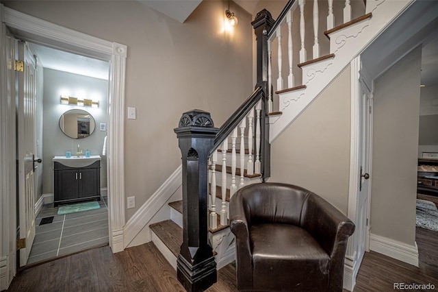 stairway featuring wood-type flooring and sink