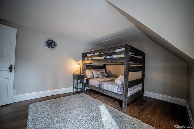 bedroom featuring dark hardwood / wood-style flooring and lofted ceiling