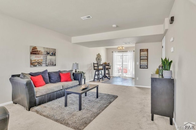 living room with carpet and an inviting chandelier