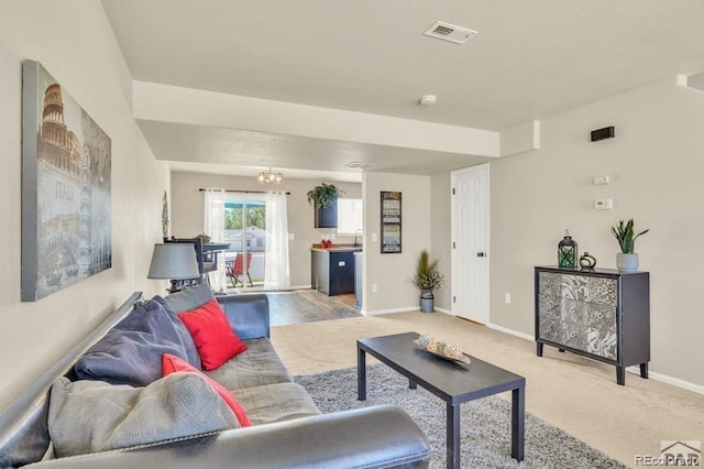 carpeted living room featuring a chandelier