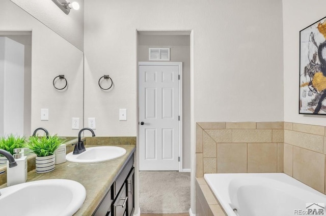 bathroom with vanity and tiled bath