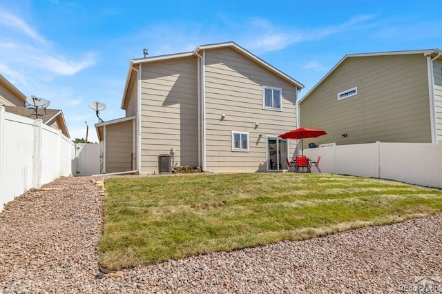 rear view of house with a yard and central AC