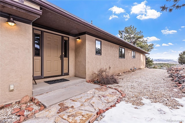 entrance to property featuring stucco siding