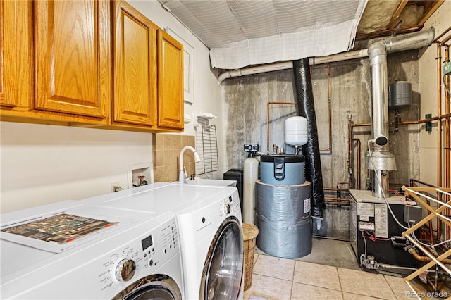 washroom featuring cabinet space, a heating unit, washer and dryer, water heater, and a sink