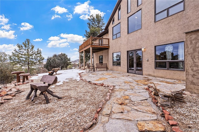 view of yard with a wooden deck, french doors, and a patio